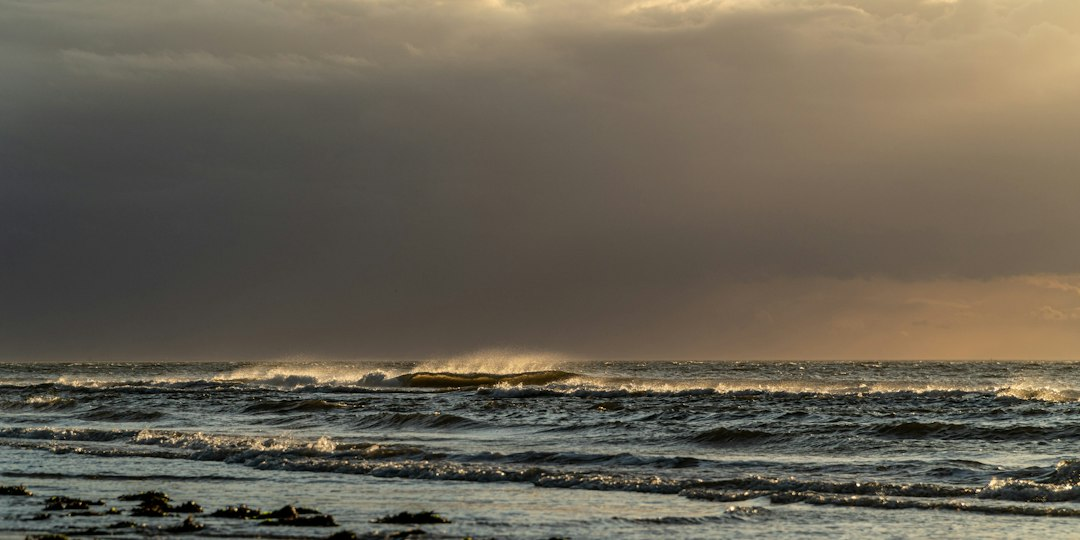 A boat sailing on choppy ocean waves at sunset, a reminder that Jesus is in the boat when disaster strikes