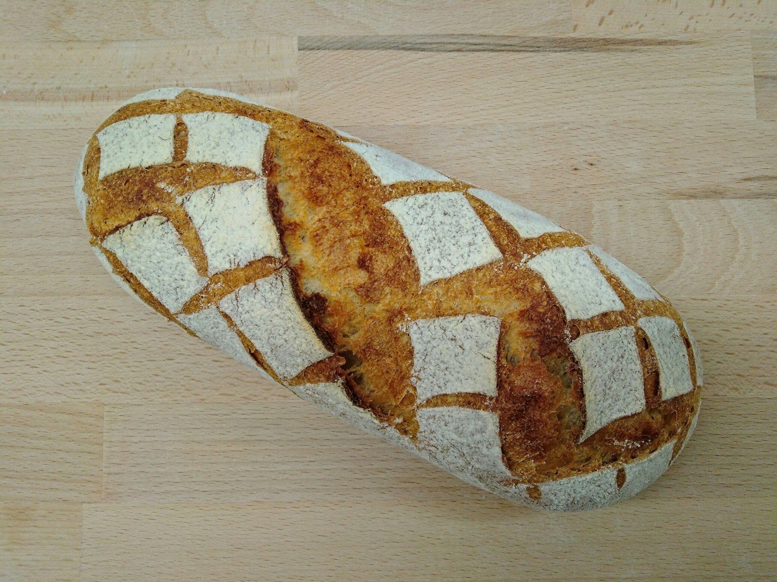 A loaf of bread on a wooden table, a reminder of the daily bread line in the Lord’s Prayer