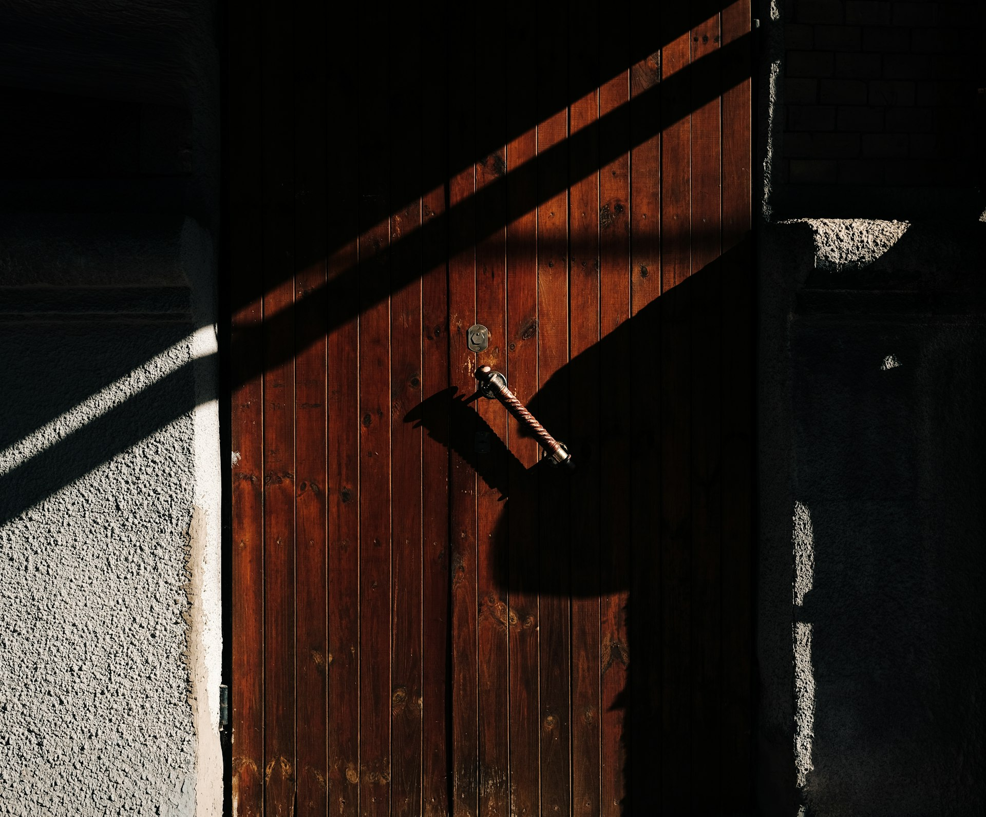 A wooden door in strong light, picturing Jesus at the door in Revelation 3:20