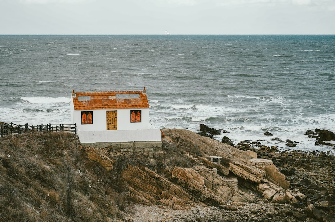 A small white house built on a rocky coast by the sea, a picture of staying steady through big life changes
